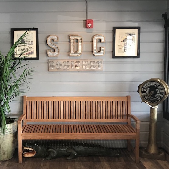 Wooden bench and SDC Bohicket on the wall.